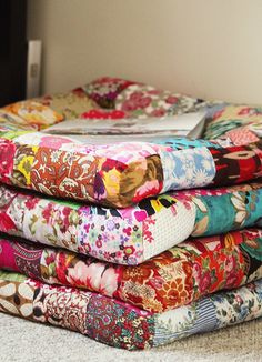 a stack of colorful fabrics sitting on top of a floor