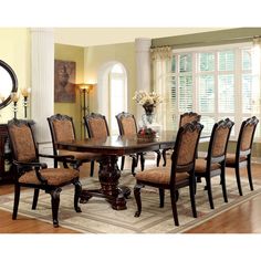 a dining room table with chairs around it and a rug on the floor next to it