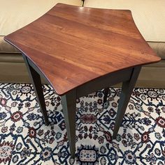 a wooden table sitting on top of a rug