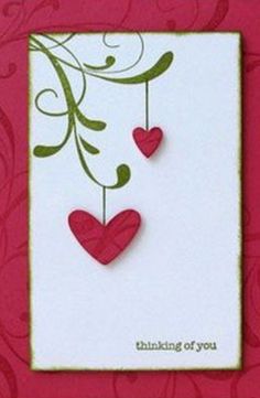 a card with two hearts hanging from it's side and the words thinking of you