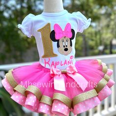 a pink and gold minnie mouse 1st birthday tutu skirt outfit with the number one on it