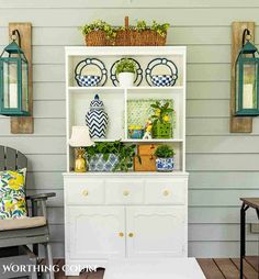 a white hutch with blue and yellow decorations on it's front porch area