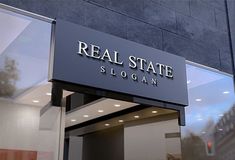 a sign that reads real state on the side of a building in front of a glass door