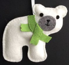 a felt polar bear ornament with a green ribbon around it's neck