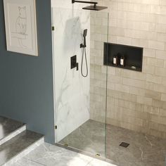 a walk in shower sitting next to a white tiled wall and floor with black accents