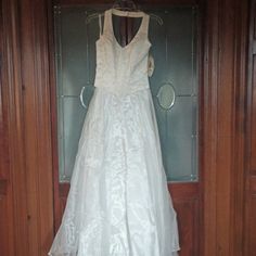 a white dress hanging on a wooden door