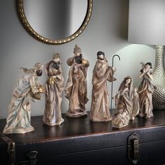 a group of figurines sitting on top of a table next to a lamp