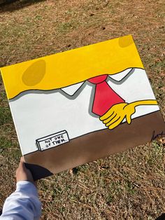 a person holding up a large piece of art that looks like the simpsons character from the simpsons