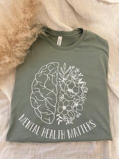 Your Mental Health MATTERS!  May is Mental Health Awareness month and Green is the color for Mental Health Awareness so this shirt is on a Heathered Sage Green Bella Canvas Tee also available in Sand (Gildan Shirt) with black vinyl.  matching Iced coffee Cup is also available here:  https://www.etsy.com/listing/1141509276/mental-health-matters-beer-can-glass?ref=listings_manager_grid Made using a heat press and premium vinyl Sizes are unisex so order true to size or go up a size for an oversized Green Letter Print Shirt For Spring, Mental Health T Shirts, Mental Health Awareness Month, Iced Coffee Cup, Awareness Shirt, Bella Canvas Tees, Young T, Mental Health Matters, Health Matters