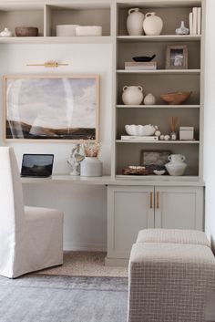 a living room filled with lots of white furniture and shelves full of vases on top of them