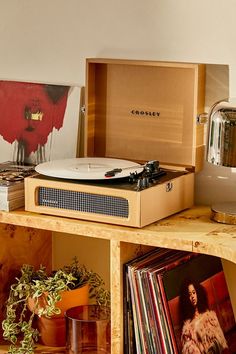 a record player sitting on top of a wooden shelf