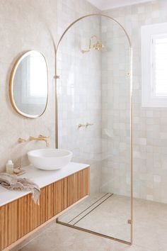 a bathroom with a sink, mirror and shower stall in the corner next to it