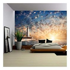 a bedroom scene with the sun setting over the water and clouds in the sky above