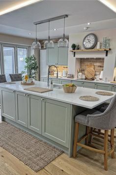 a large kitchen with an island in the middle and two stools at the end