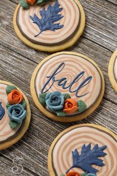 four decorated cookies with leaves and the word fall on them