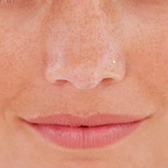 a woman's face with freckles on her cheeks and nose is shown