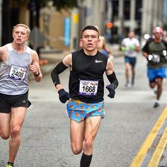 two men running in a marathon on the street