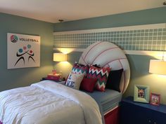 a bedroom with a bed, two lamps and pictures on the wall above it is decorated in blue and white