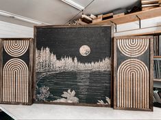 three black and white paintings on display in a room with bookshelves behind them