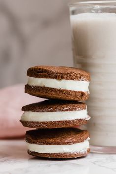 three cookies stacked on top of each other next to a glass of milk