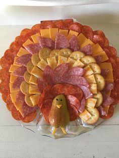 a turkey shaped platter with crackers, cheeses and meats on it