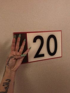 a person holding up a sign with the number twenty on it