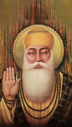 an old man with white hair and beard wearing a yellow turban holding his hand up