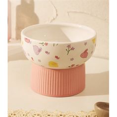 two bowls are sitting next to each other on a doily, one is pink and the other is white