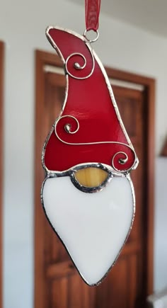 a red and white glass ornament hanging from a hook in a door way