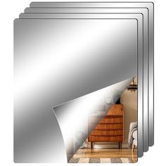 a set of four mirrors sitting on top of a wooden floor next to a dresser