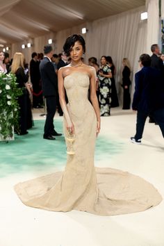 an image of a woman in a dress at the oscars awards ceremony with other people standing around