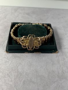 Victorian expansion bracelet.  Only marking says patented 1905.  Gold tone links connected by small wires which allow it to expand.   This is a unique style of expansion bracelet that you don't see a lot.  Measures 6 1/2 inches around and expands to about 7 inches.  Centerpiece is 1 inch tall by 1 1/4 inch wide. Average condition for the age - a fair amount of wear to the back of the links and some wear to the high points on the outside of the links.  Due to age design the bracelet all the links don't automatically expand and contract.   Center piece is not inscribed. Victorian Gold, Antique Victorian, Chain Link Bracelet, The Expanse, Link Bracelets, Chain Link, 1 Inch, Unique Style, 4 Inch