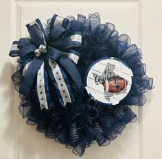 a close up of a wreath on a door with blue and white ribbon around it