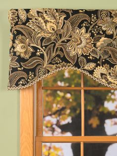 a window with a black and gold valance hanging from it's side next to a window sill