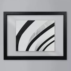 a black and white photo hanging on the wall above a framed art print with an abstract design