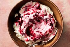 a bowl filled with whipped cream and cranberry sauce on top of a table