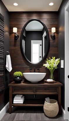 a bathroom with a round mirror above the sink and a wooden counter top under it