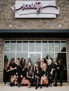 a group of women posing for a photo in front of a salon