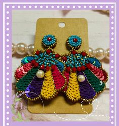 a pair of colorful beaded earrings on top of a card