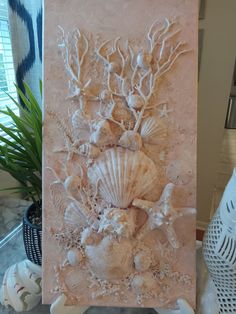 an art piece with shells and seaweed on it