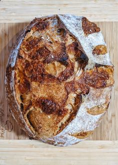 a loaf of bread sitting on top of a wooden cutting board