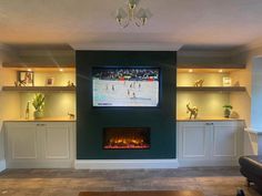 a living room filled with furniture and a flat screen tv mounted on the wall above a fire place