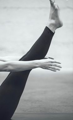 a black and white photo of a woman stretching her arms out with the words yoga written below it