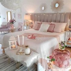 a bedroom decorated in pink and white with candles on the bed