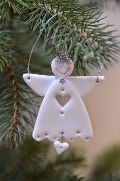 a white angel ornament hanging from a christmas tree