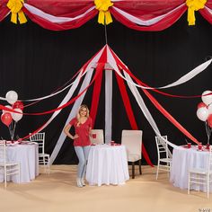 a woman standing in front of a table with red and white decorations