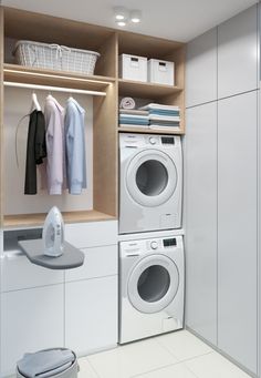 a washer and dryer sitting in a room next to each other with clothes hanging on the shelves