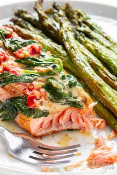 a white plate topped with asparagus and salmon