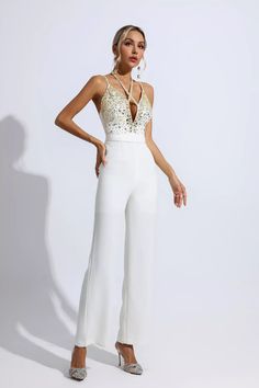 The Matilda White Sequin Embellished Jumpsuit will be your luxurious piece, the perfect expression of elegance, making you the ultimate highlight. Refreshing your wardrobe with a chic halter neck and deep V-neck detailing, this piece sparkles with sequin and crystal stone accents, while spaghetti straps add a touch of classic appeal. Make a bold statement in this stunning jumpsuit. Wear it with heels and a tote for an important event.Length: Approx 145cmMaterials: PolyesterGentle Dry Clean OnlyT White Long Jumpsuit, Embellished Jumpsuit, Glitter Wedding Dress, 2023 Clothing, Bandage Midi Dress, Floral Shirt Dress, Jumpsuit Party, Puff Sleeve Dresses, White Jumpsuit