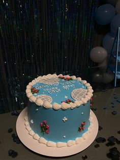 a blue and white birthday cake sitting on top of a table